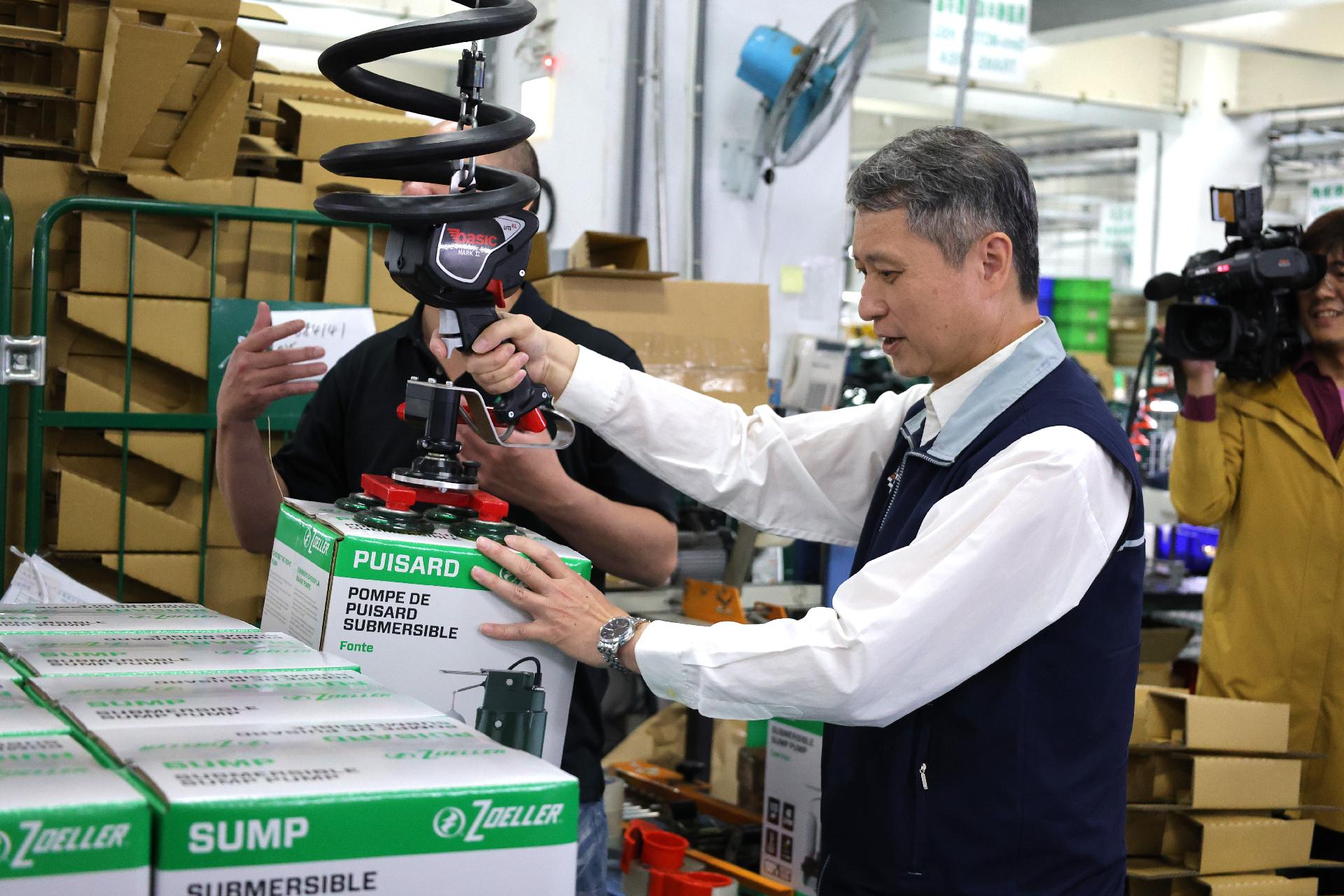 圖說3：勞工局長陳瑞嘉體驗真空吸盤搬運設備，將重達16公斤的產品輕鬆移動至棧板上。