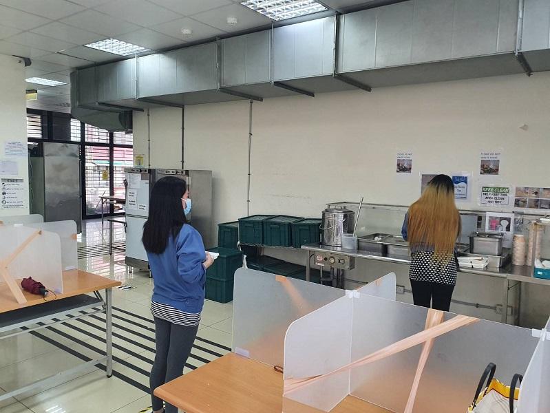 移工餐廳保持社交距離等待取餐，座位並設置隔板以梅花座排列